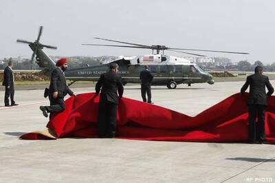 Winds blow away red carpet laid out for Obama